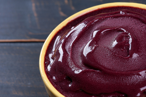 Açaí congelado em uma tigela de madeira em uma mesa preta - receitas com açaí - Assaí Atacadista
