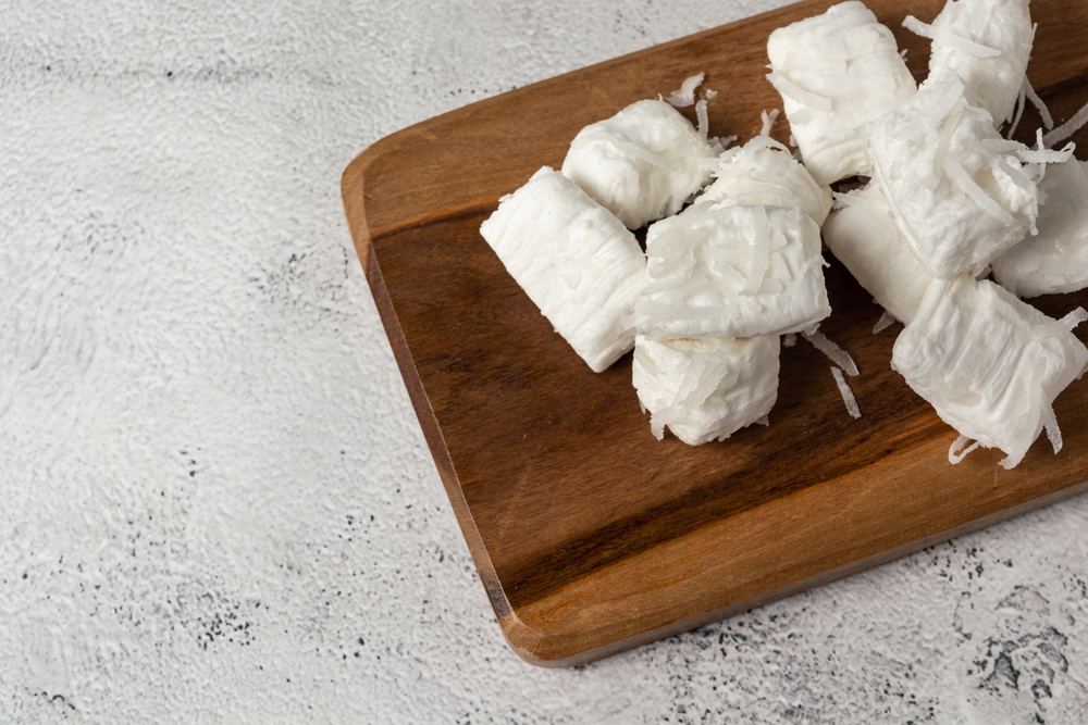 bala de coco em uma tábua de madeira - comida afetiva - Assaí Atacadista