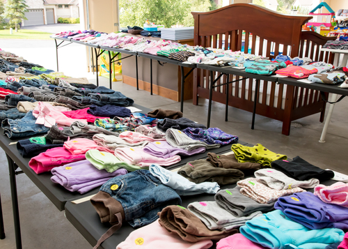 bazar com mesas com roupas infantis dobradas - poupar dinheiro com filhos - Assaí Atacadista