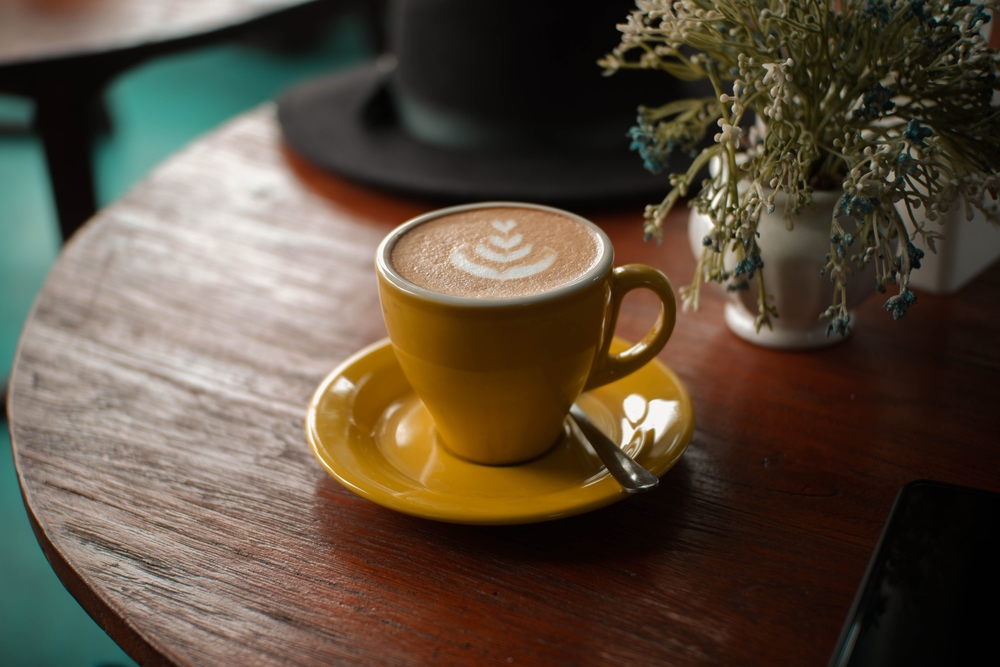 café latte com arte em uma xícara amarela - tipos de café - Assaí Atacadista