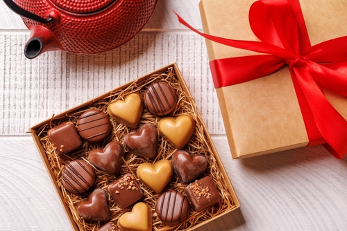 caixa de bombom com vários chocolates com formato de corações e uma caixa com um laço vermelho ao lado - presentes de Páscoa - Assaí Atacadista