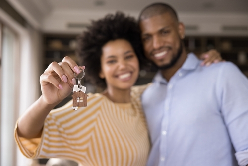 casal de pessoas negras segurando a chave de uma casa própria - Prêmio Aniversário Assaí