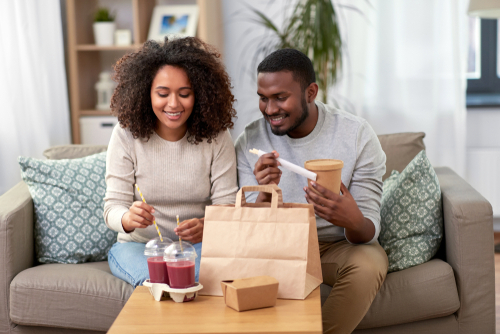 casal de pessoas pretas com um delivery de comida - assaí atacadista