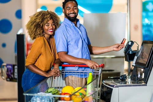 casal de pessoas pretas usando um cartão para pagar as compras no mercado - formas de pagamento Assaí Atacadista