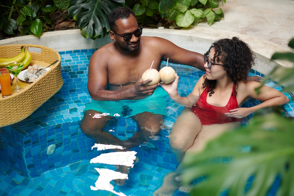casal interacial descansando em uma piscina - realização pessoal - Assaí Atacadista