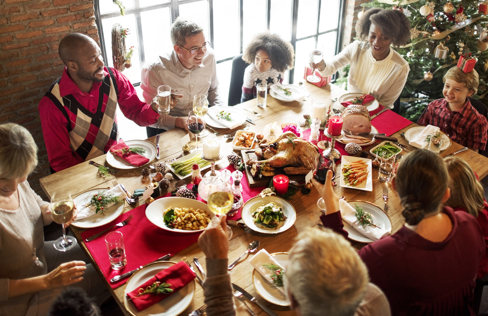 ceia de Natal com uma família grande ao redor de uma mesa com decorações de Natal e comida - compras de Natal - Assaí Atacadista