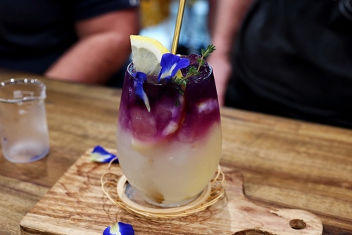 copo com bebida roxa e amarela em uma mesa - bebidas sem álcool - Assaí Atacadista - Imagem: Shutterstock