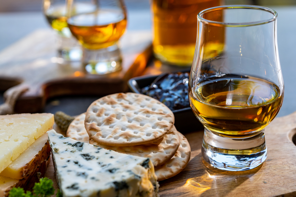 copo de whisky acompanhado de petiscos - bebidas e comidas que combinam - Assaí Atacadista