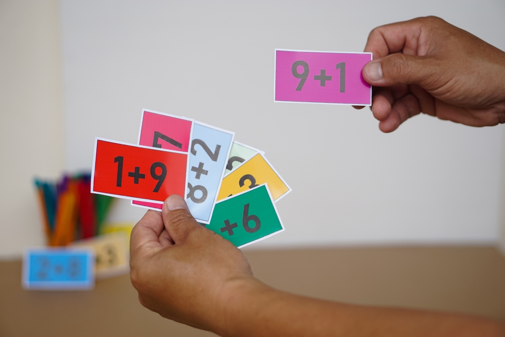criança negra segurando cartões com contas de matemáticas - presentes para crianças - Assaí Atacadista