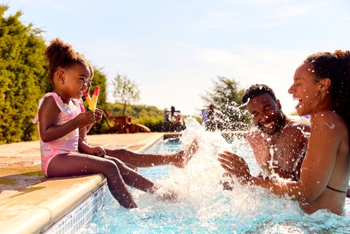 crianças negras brincando com os pais na piscina - o que fazer no Dia das Crianças - Assaí Atacadista