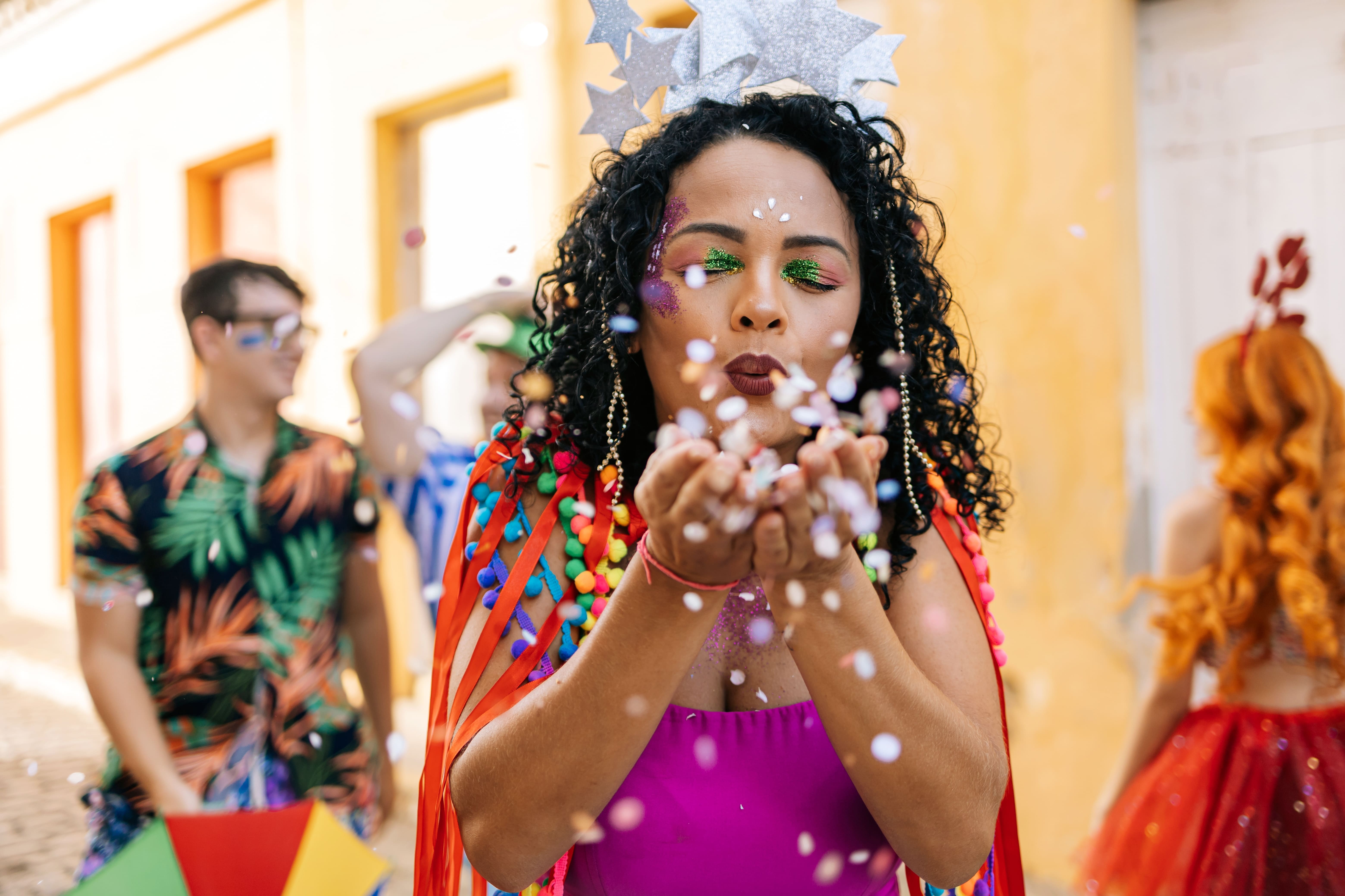 mulher assoprando confetes de carnaval - assaí atacadista