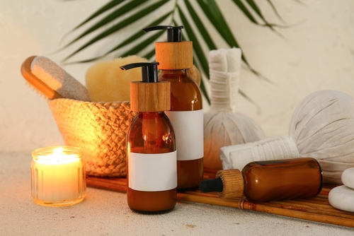 embalagens marrons com outros produtos de beleza acompanhados de uma pequena vela - spa em casa - Assaí Atacadista