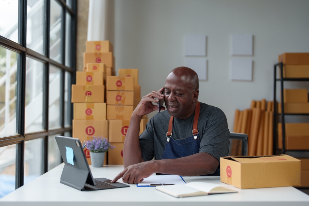 empreendedor negro concentrado em um escritório falando ao celular - combate à desinformação - Assaí Atacadista