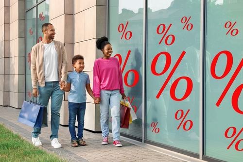 família com menino na calçada vendo símbolo de promoção felizes - crianças na Páscoa - Assaí Atacadista