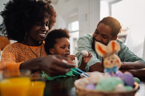 família feliz com uma criança fazendo artesanato na Páscoa - Páscoa em família - Assaí Atacadista