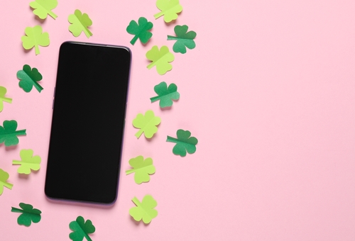 fundo rosa com celular preto e pequenos trevos verde-claros e escuros - Assaí Atacadista - pagamento com Pix