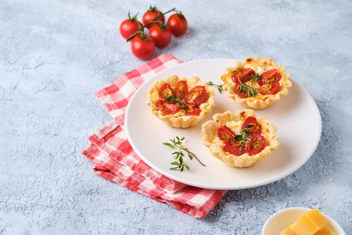 guardanapo vermelho flanelado com um prato com mini tortas recheadas com tomate - pratos para a páscoa - Assaí Atacadista