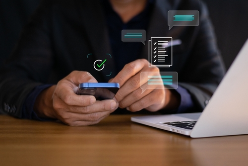 homem branco segurando celular com informações - incentivos fiscais - Assaí Atacadista