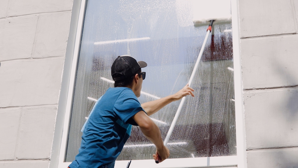  homem ensaboando uma vitrine com um equipamento de limpeza nas mãos - limpeza de vitrines - Assaí Atacadista