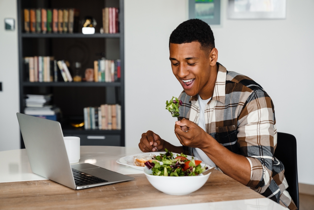 homem negro jovem feliz comendo salada - Assaí Atacadista - bom-humor