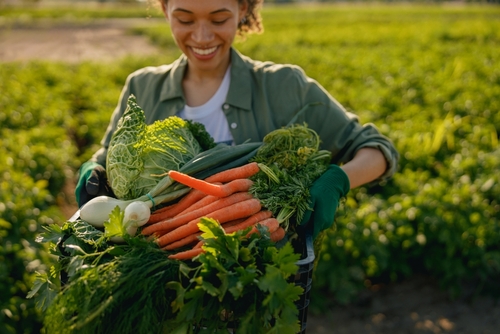 jovem negra segurando verduras - hortifrúti - FeirAssaí Atacadista