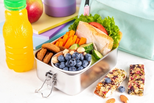 lancheira com frutas castanhas sanduíche barra de cereal e uma garrafa de suco de laranja-alimentação infantil-Assaí Atacadista