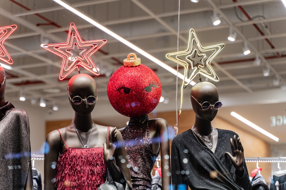 manequins em uma vitrine com estrelas de Natal e uma bola de enfeite no lugar da cabeça com olhos - marketing sensorial - Assaí Atacadista