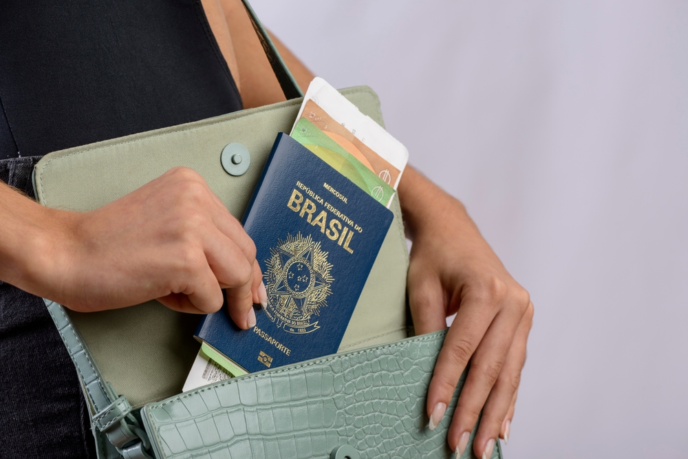mãos brancas femininas colocando documentos em uma bolsa - Assaí Atacadista - viagem de navio