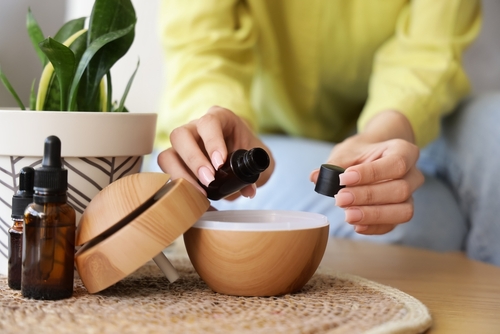 mãos femininas colocando óleo essencial em um aromatizador de ambientes - aromaterapia - Assaí Atacadista