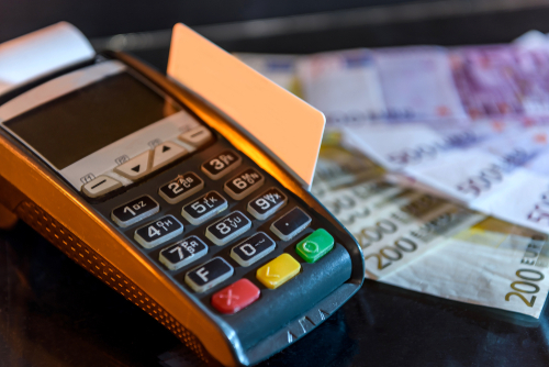 maquininha de cartão e notas de dinheiro físico no fundo desfocado - Dia do Consumidor - Assaí Atacadista - Imagem: Shutterstock