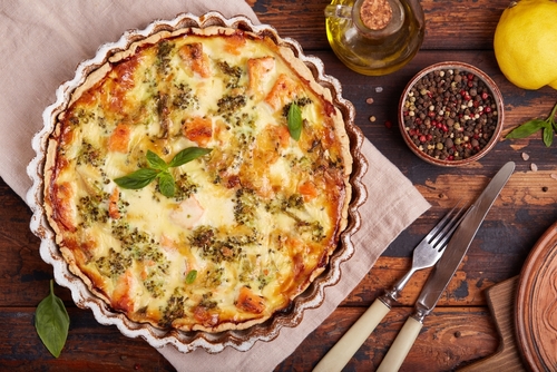 mesa com especiarias, talheres e uma forma com quiche - salgados de padaria - Assaí Atacadista