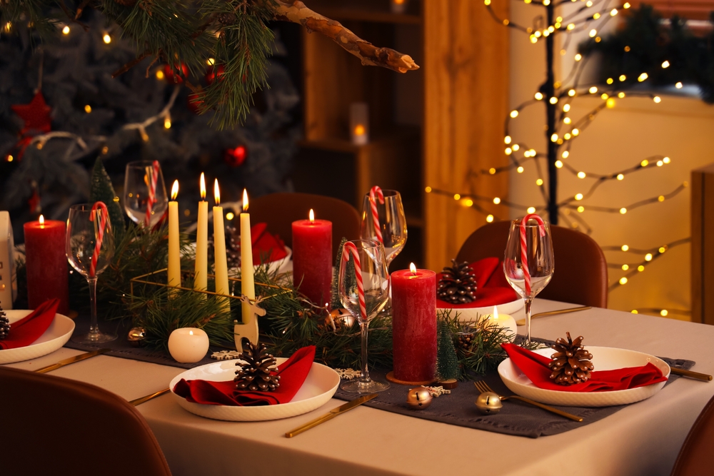 mesa posta de Natal com decorações vermelhas e uma árvore de Natal no fundo - Assaí Atacadista