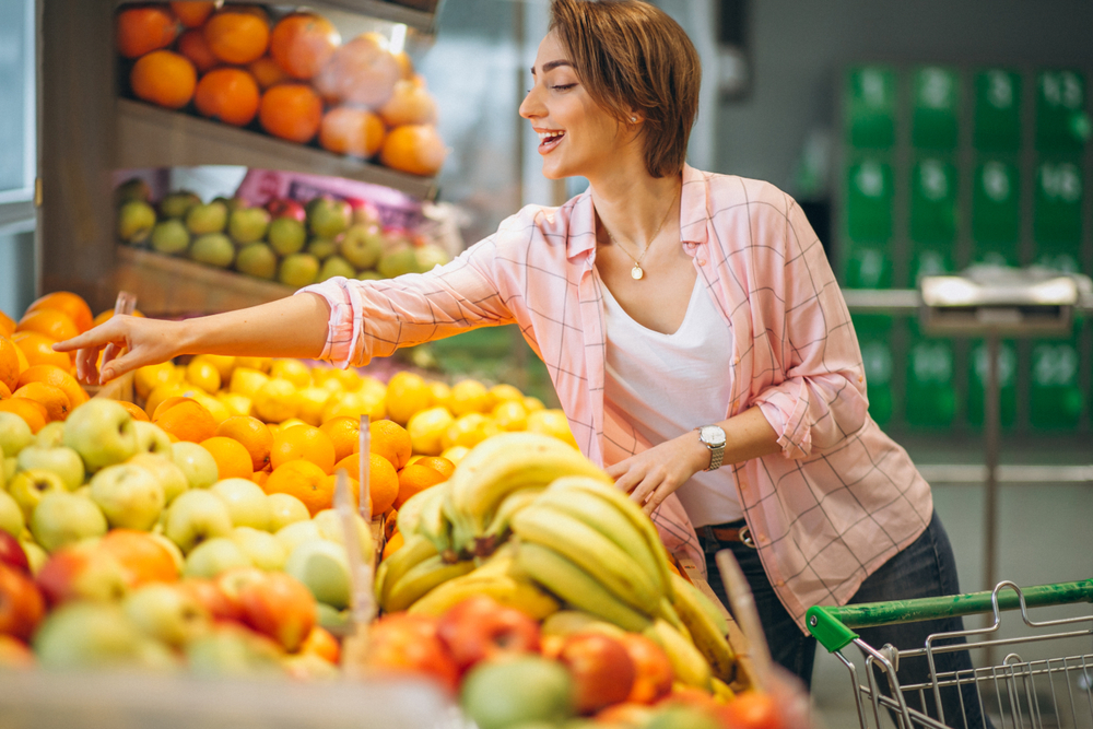 mulher branca escolhendo frutas na feira do mercado - Assaí Atacadista