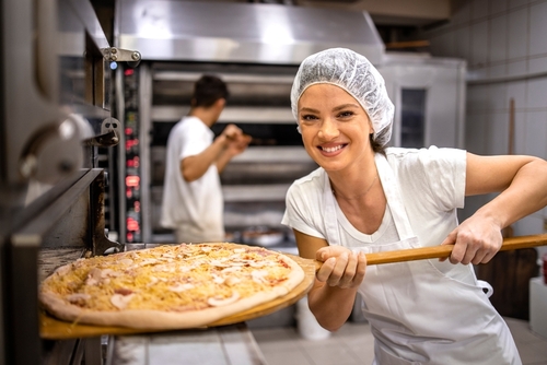 mulher colocando pizza no forno em uma padaria - assaí atacadista