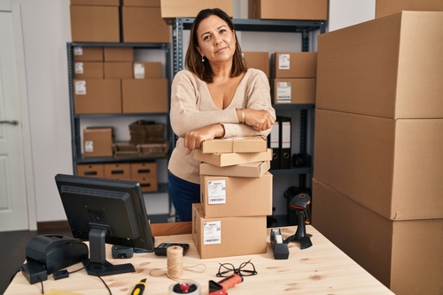 mulher empreendedora com caixas no estoque do seu négocio - assaí atacadista