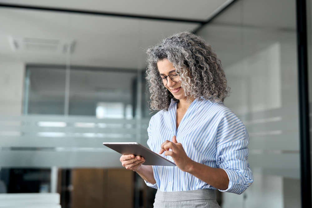 mulher empreendedora grisalha definindo corte de gastos no tablet - economizar dinheiro - Assaí Atacadista