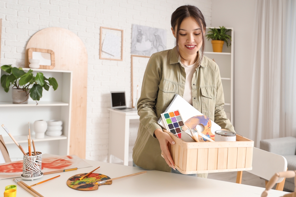 mulher jovem segurando uma caixa com materiais de arte - empreendedorismo feminino - Assaí Atacadista