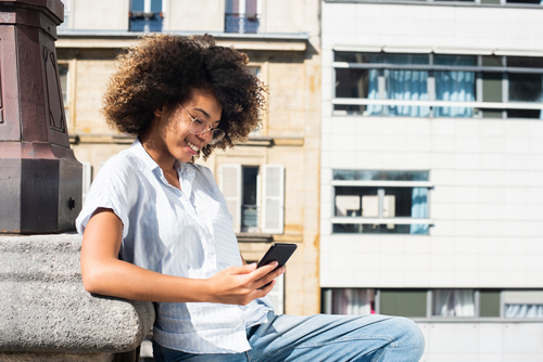 mulher negra olhando o celular - TikTok para negócios - assaí Atacadista