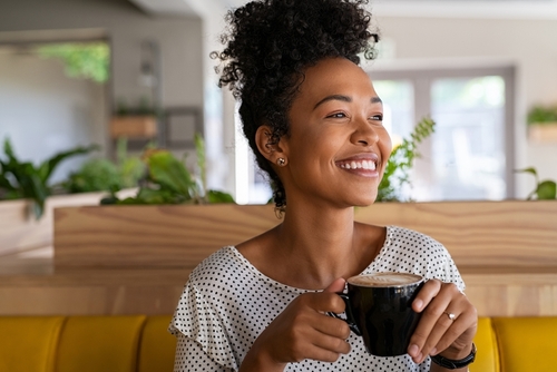 mulher negra tomando café em uma cafeteria - café pilão e assaí atacadista