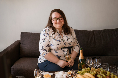 mulher plus size feliz tomando vinho branco de presente no Dia da Mulher - Assaí Atacadista