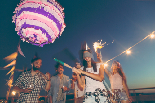 mulher vendada tentando acertar uma pinata - festa de aniversário no México - assaí atacadista