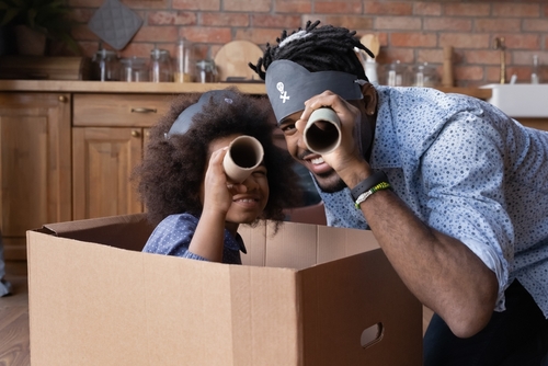 pai e filha negra brincando de pirata em uma caixa de papelão - atividades familiares - Assaí Atacadista