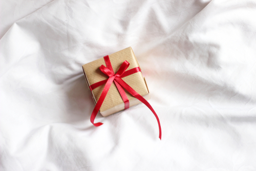 pequena caixa de presente com um laço vermelho em um fundo branco - mesversário - Assaí Atacadista