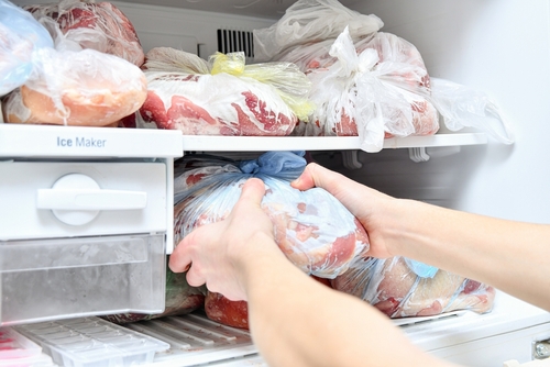 pessoa armazenando carnes no freezer - armazenar carne - açougue do assaí atacadista
