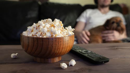 pessoa com cachorro assistindo a um filme - Carnaval em casa - Assaí Atacadista