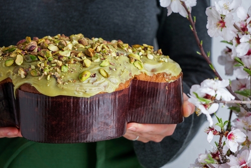 pessoa segurando uma colomba pascal de pistache - receita de doces para a Páscoa - Assaí Atacadista