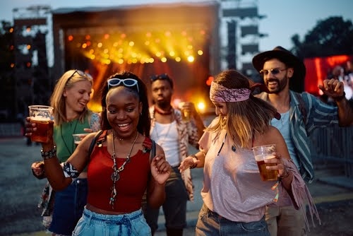 pessoas felizes dançando com bebidas na mão - festivais musicais - Assaí Atacadista