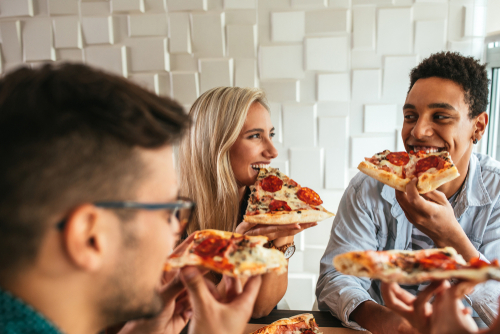 pessoas jovens comendo pizza em uma padaria - assaí atacadista