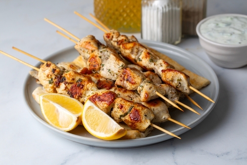 prato branco com espetinhos de frango e fatias de limão - churrasco de Carnaval - Assaí Atacadista