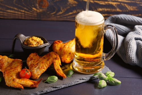 prato com asas de frango e um copo de cerveja do lado - churrasco de Carnaval - Assaí Atacadista